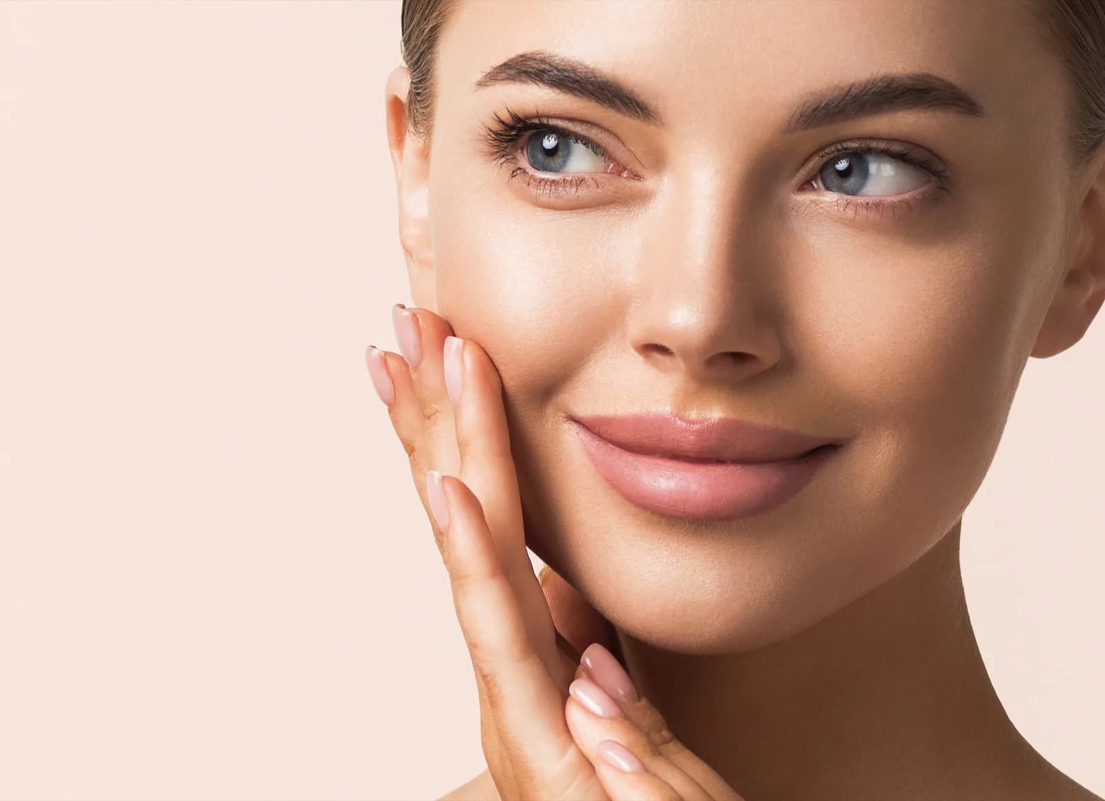 Woman touching her cheek with healthy, radiant skin